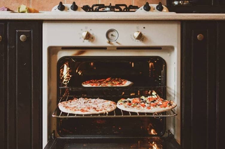 Baking soda paste being applied to the inside of an oven