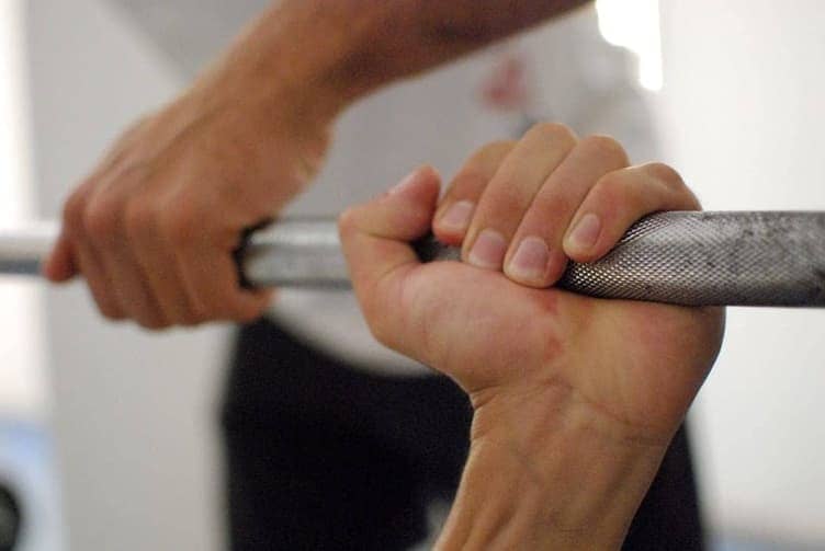 Person lowering slowly from a pull-up bar doing a negative rep