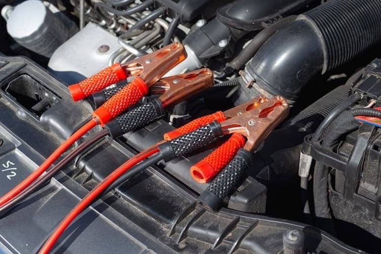 Jumper cables connected between two car batteries