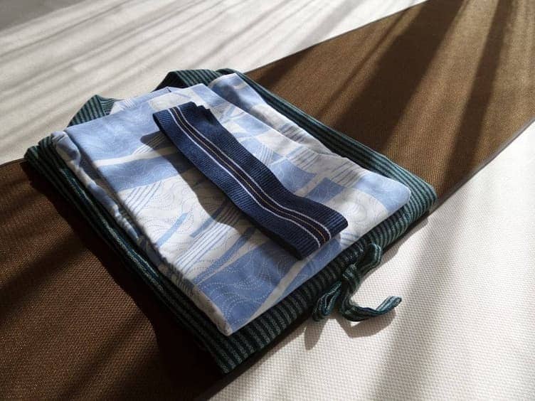Clothes and travel items laid out on a bed before packing