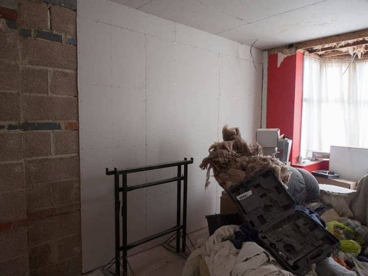 Room being prepped for painting with drop cloths and tape