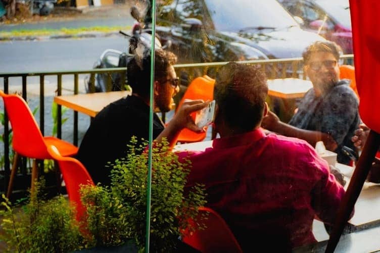 Group of people chatting in a sunny outdoor cafe