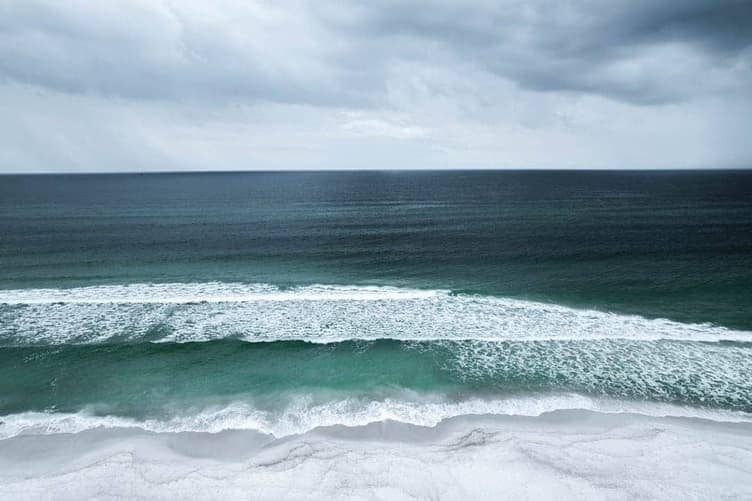 Ocean waves breaking near a sandy beach