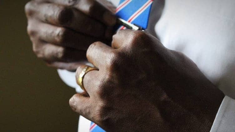 Close-up of hands adjusting a freshly tied bow tie